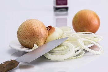 Onion Bulbs and Sliced Onion on Ceramic Plate