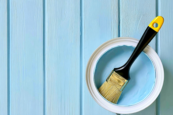 Open White Paint Can with Brush on Blue Wooden Plank
