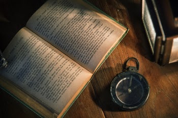 Opened Book Beside Compass