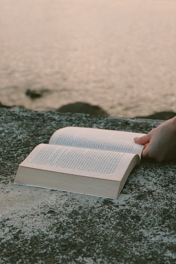Opened Book on Grey Concrete Near Beach