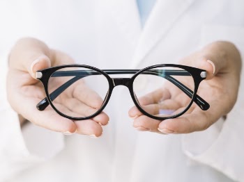 Ophthalmologist showing pair of eyeglasses Free Photo