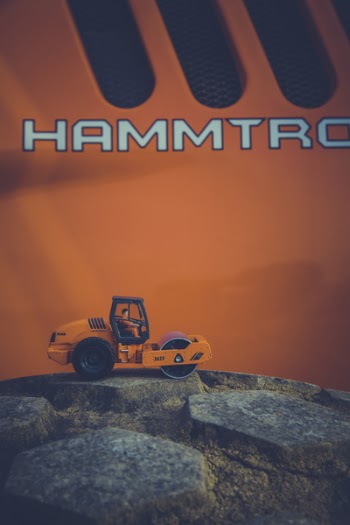 Orange and Black Road Roller Toy on Black Stone