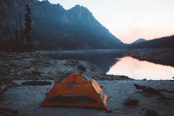 orange and gray camping tent near body of water