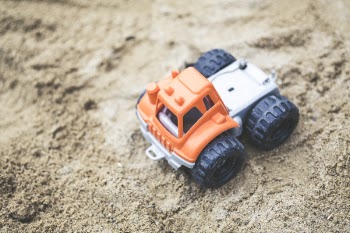 Orange and Gray Plastic Truck Toy on Sand