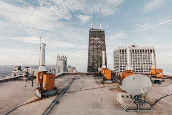 Orange and White Machines and Buildings Under Blue Sky