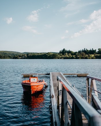Orange Boat In Body Of Water Beside Dock