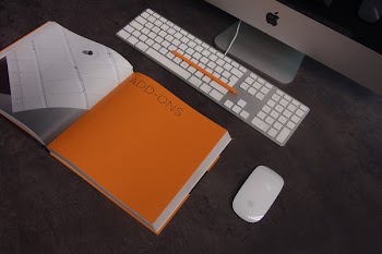 Orange Book in Distance With Silver Imac