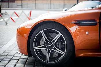Orange Car Parked Near Grey Triangular Sign during Daytime