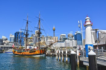 Orange Galleon Ship on Body of Water Beside City Buildings