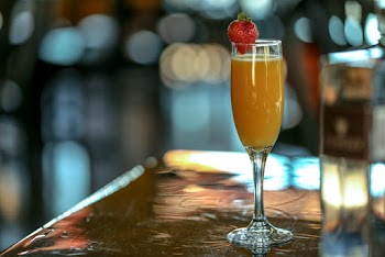 Orange Liquid Filled Champagne Flute on Brown Surface