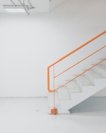 orange metal railing white concrete stairs