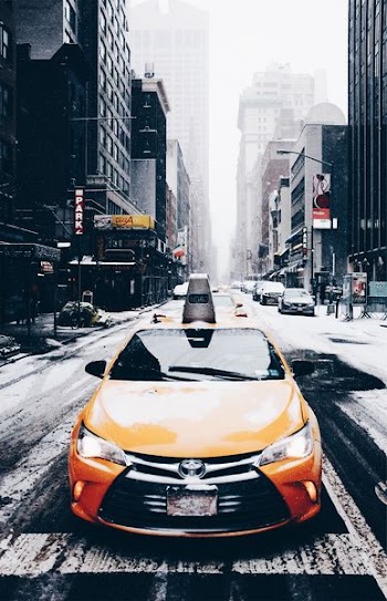 orange Toyota car on road near buildings