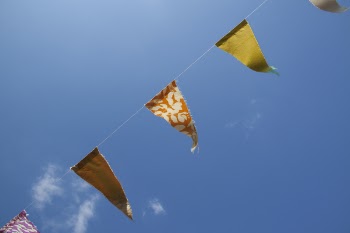 Orange Yellow and Red Flaglets Under Blue White Sky during Daytime