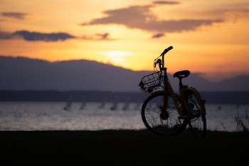 OSO bike share parked at Golden Gardens; background sailing in Puget Sound.