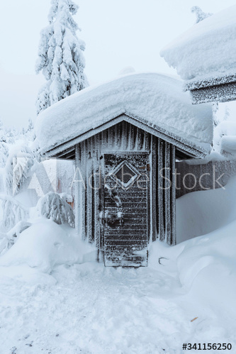 Outdoor toilet covered in snow