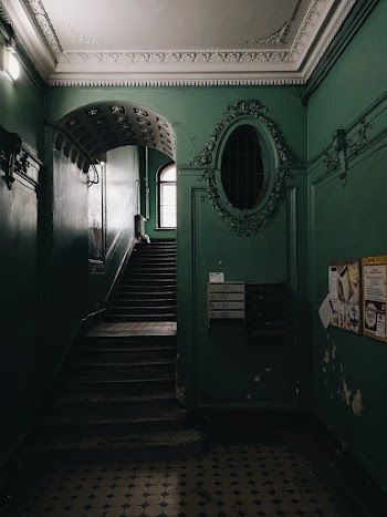 Oval Gray Framed Wall Mirror Beside Stairs