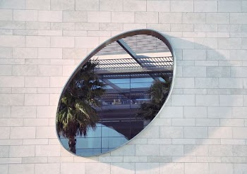 oval mirror on white brick pathway