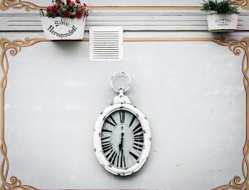 oval white analog clock display at 6 o'clock