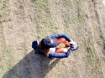 Overhead Photo of Woman Sitting on Green Grass Field