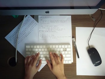 Overhead View of a Desk with Hands Typing on a Keyboard