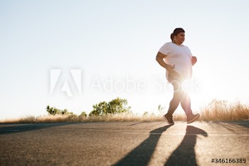 Overweight woman jogging on the highway