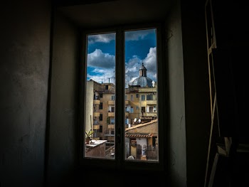 Painting of Window With View of Brown Buildings