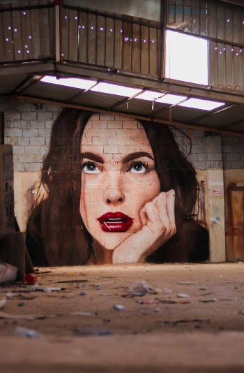 Painting on Wall of Woman's Face with Hand on Chin