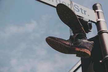 pair of black boots hanged on street post