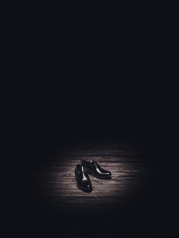Pair of Black Dress Shoes on Brown Flooring