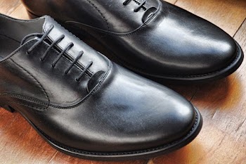 pair of black dress shoes on top of wooden surface