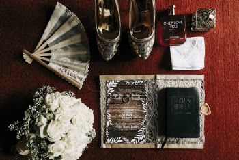 Pair of Grey Flats, Fragrance Bottle, White Bouquet and Hand Fan on Red Surface