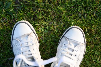 Pair of White Lace-up Sneakers on Top Green Grass