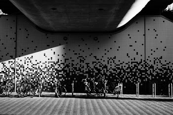 Parked Bikes Under Building in Grayscale Photography