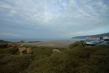 Parked Vehicle Near Body of Water Under Cloudy Sky