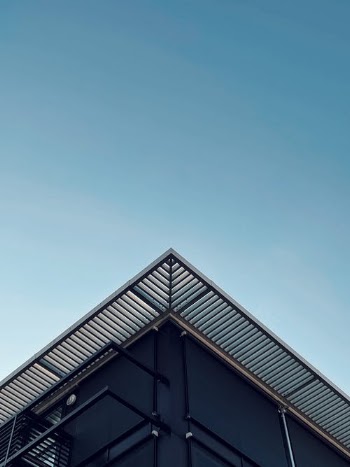 Part of modern building under cloudless blue sky · Free Stock Photo