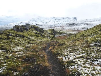 pathway between green grass hill towards snow capped mountain