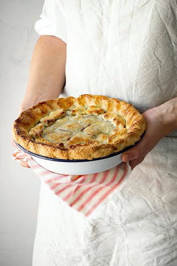 Patisserie holding a cherry pie food photography closeup