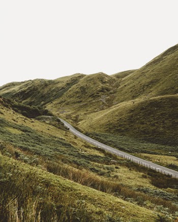 Paved Road Crossing Between Green Mountains