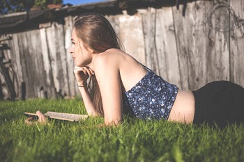 Pensive girl laying on grass