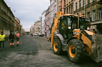 People and  construction truck on a street between buildings
