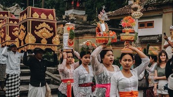 people at ceremony carrying pots