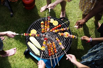 People Barbecuing Skewered Meats