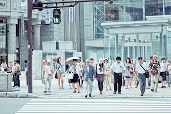 people crossing pedestrian lane near building at daytime