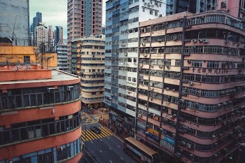 people crossing street near brown concrete buildings