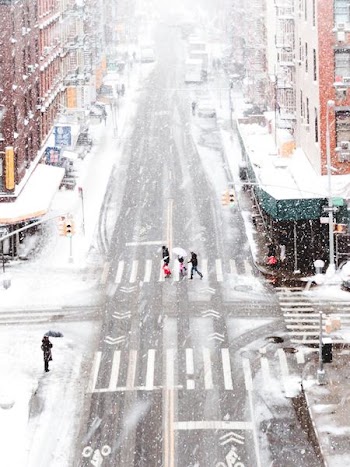 people crossing the street while snow raining