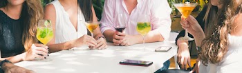 People Drinking Beverage While Sitting Near Table