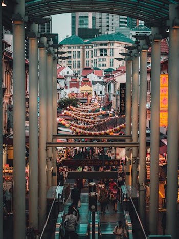people gathered on the streets surrounded by stalls and buildings