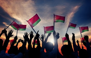 People Holding Red and Green Striped Flaglets Up High