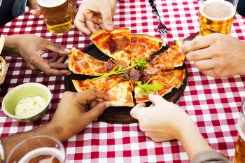People Holding Sliced Pizza