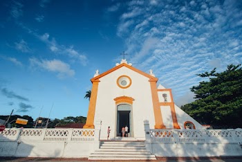 People In Front Of White And Orange Church